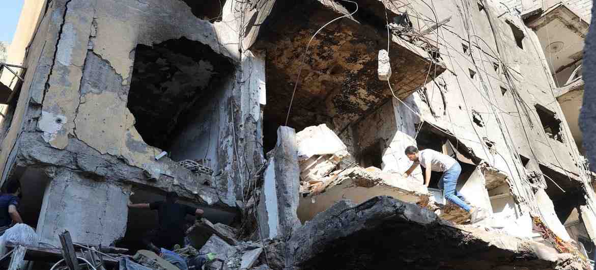UNICEF/Dar al Mussawir/Ramzi Haidar A man climbs over a destroyed building in the southern suburbs of Beirut, Lebanon.