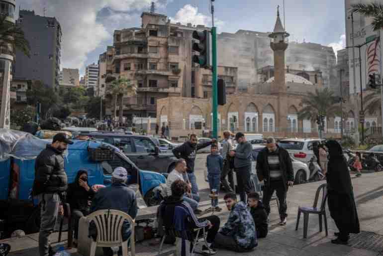 Displaced Lebanese sit on a street in Beirut after being forced to leave their homes and jobs (Getty)