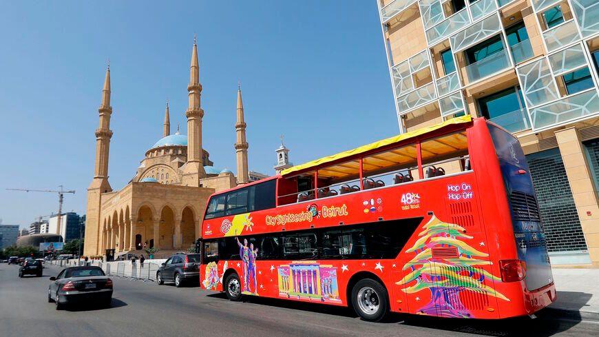 A red tourist bus in front of a mosque in the city of Beirut A red tourist bus in front of a mosque in the city of Beirut