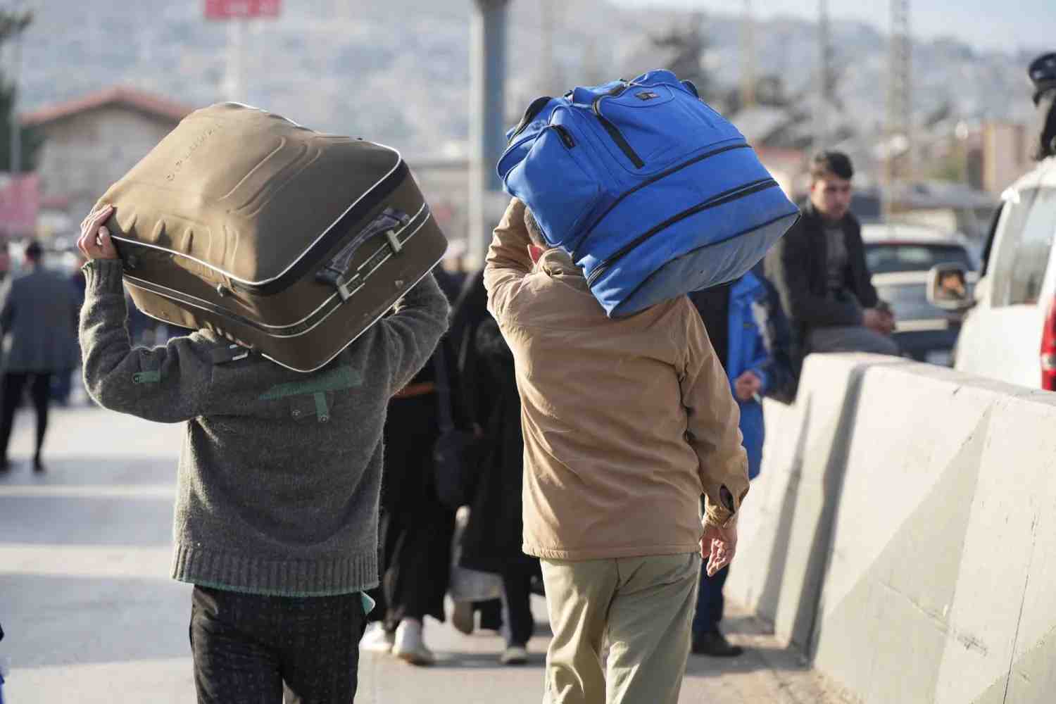 Syrian displaced people carry their belongings (Reuters).