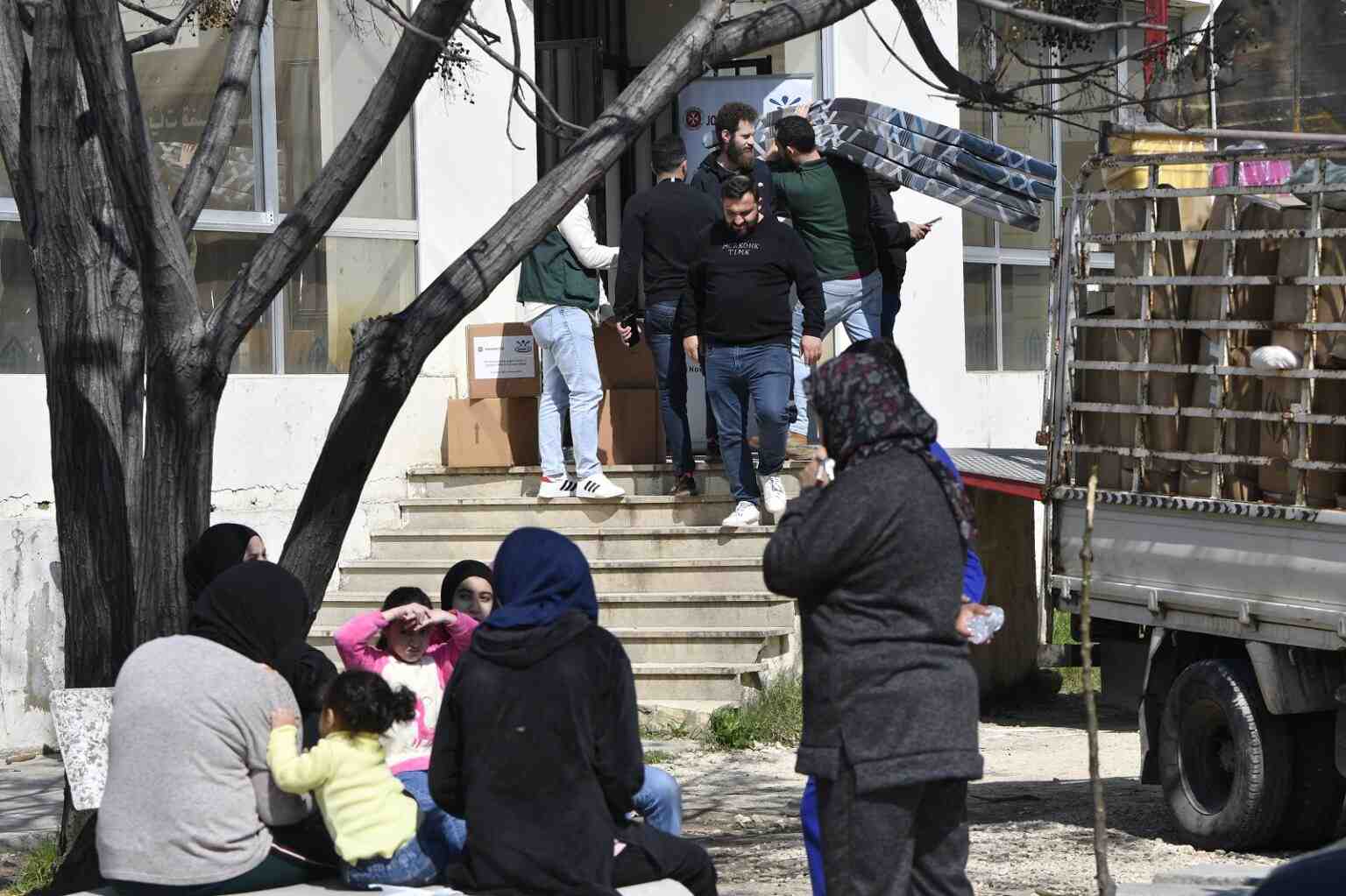 People are carrying beds inside a school