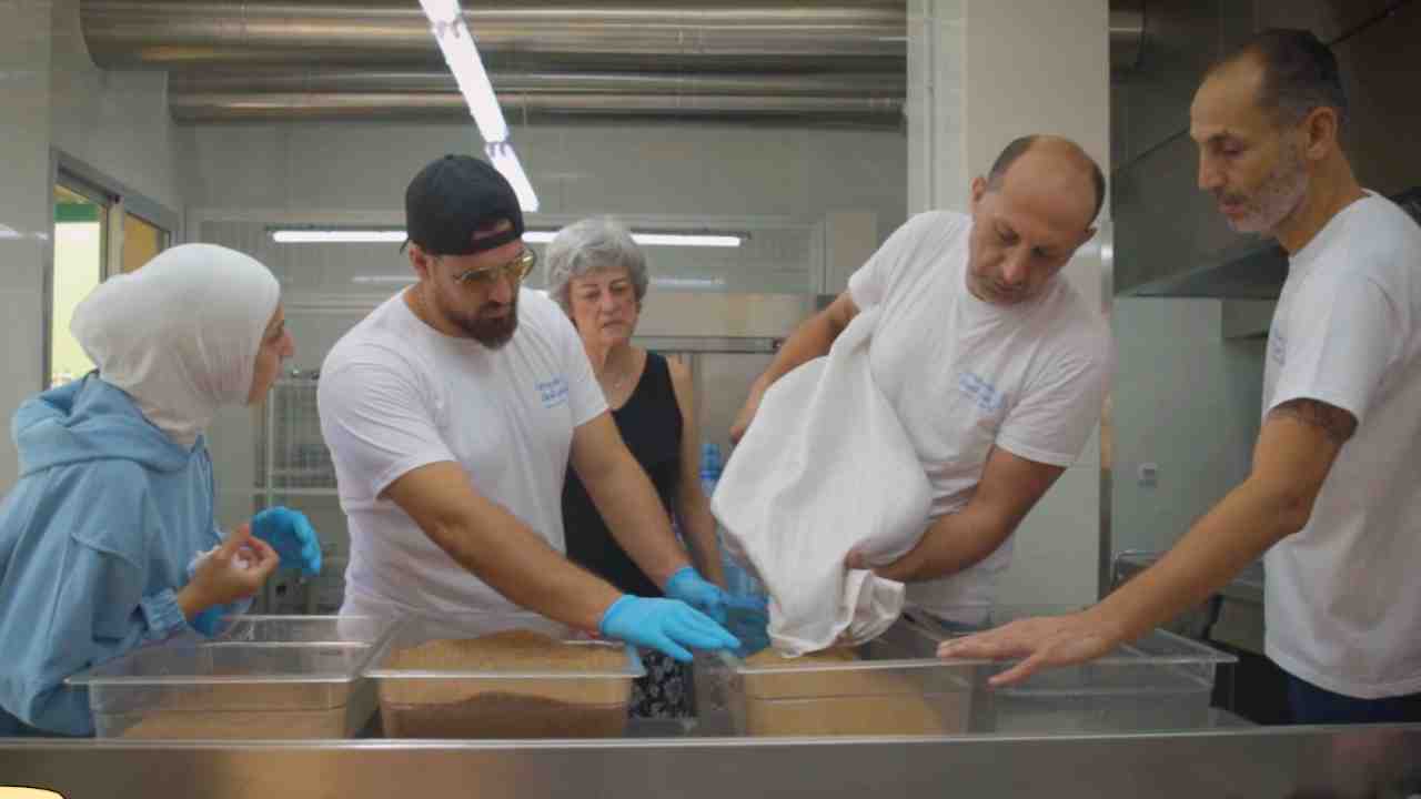 Volunteers preparing meals for displaced families in a community kitchen.
